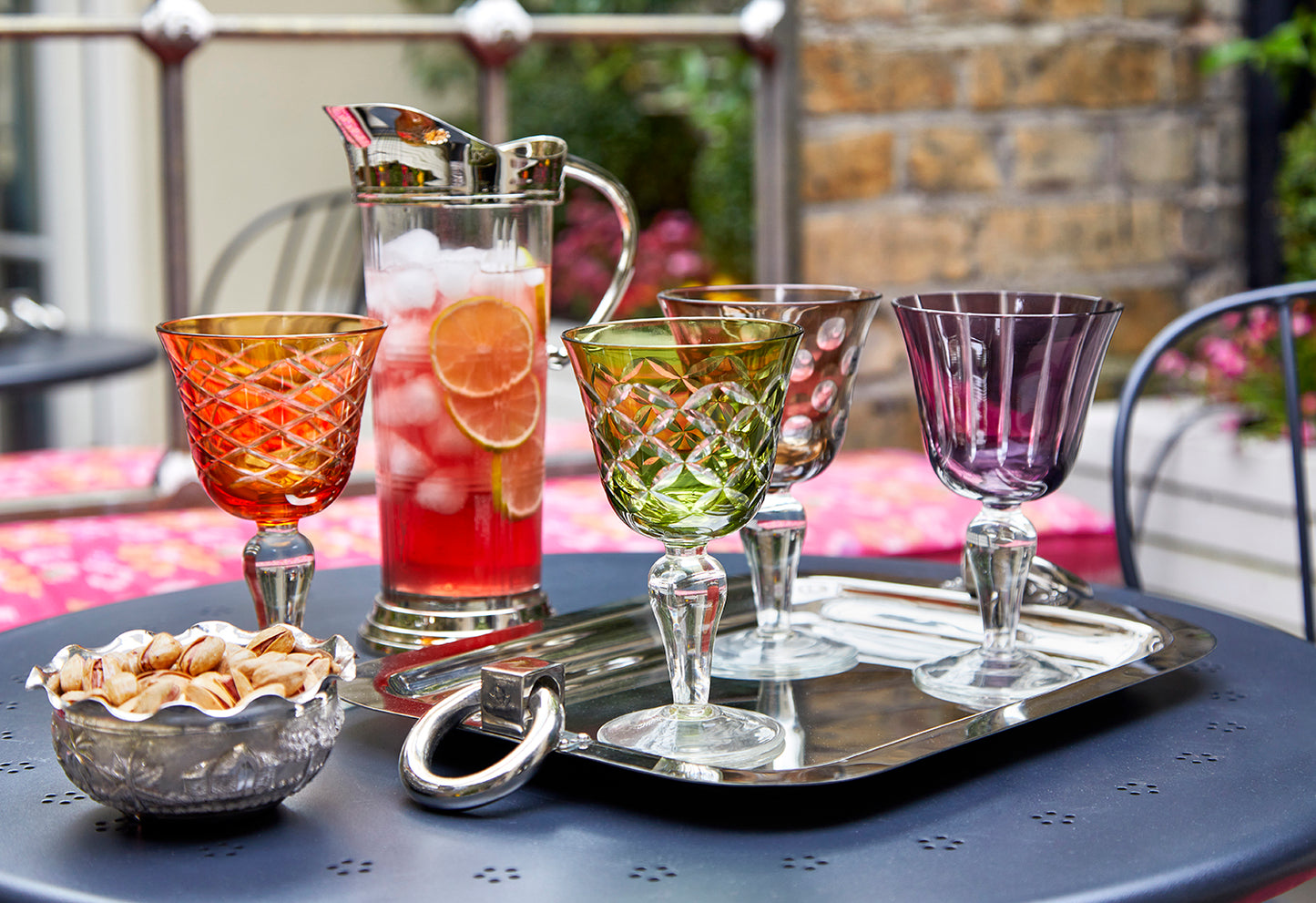 brightly coloured wine glasses on a silver tray
