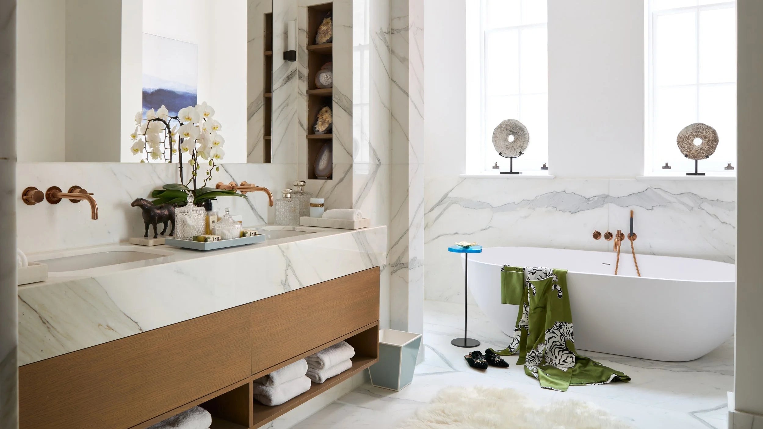 Modern bathroom with a freestanding bathtub, vanity, and decorative elements.