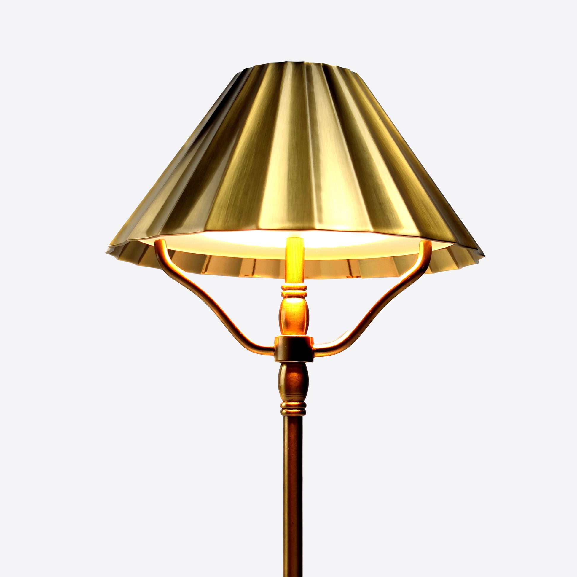 Close up of pleated effect brass shade with dimmable light on